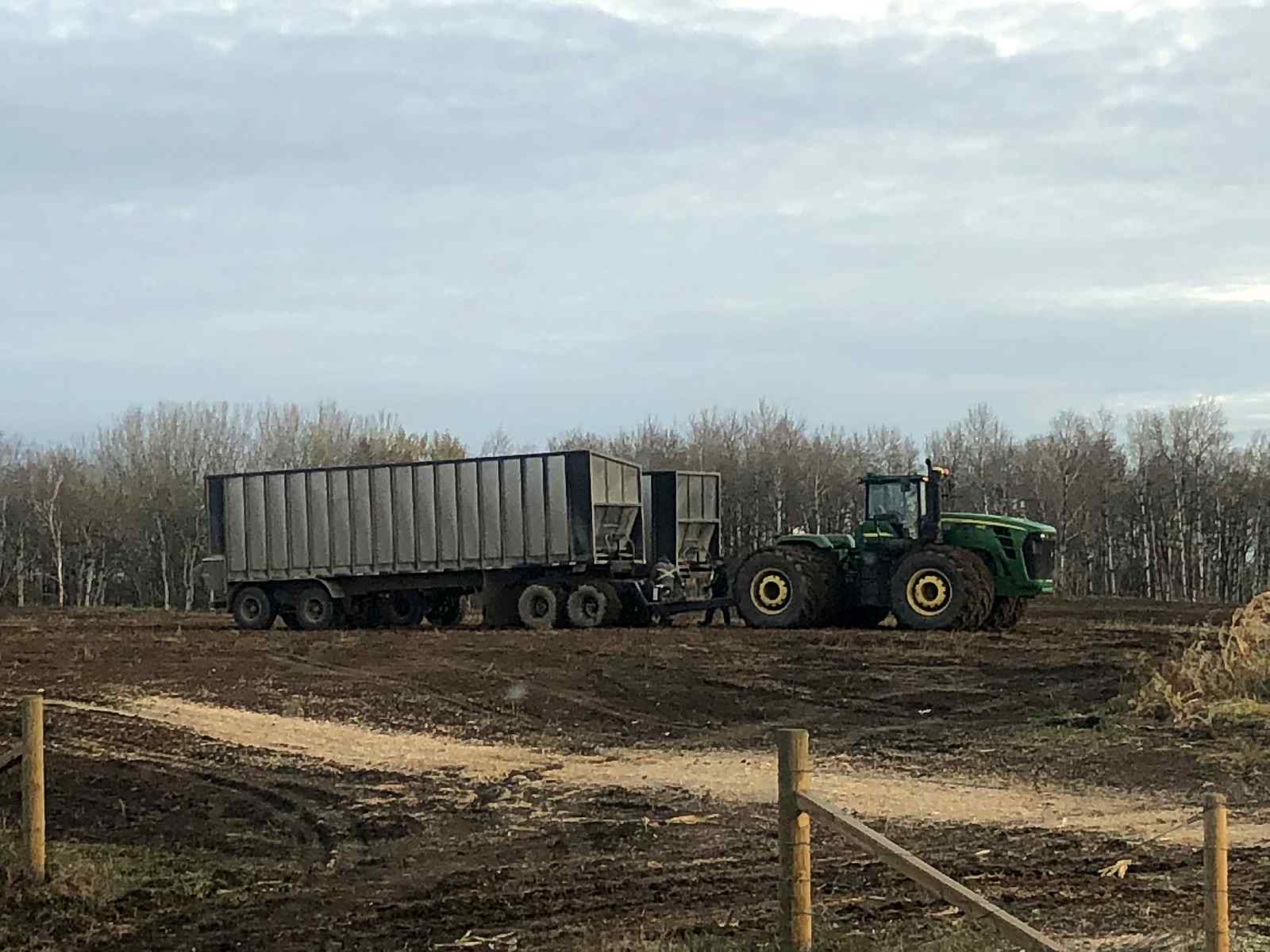 A John Deere tractor and its silage wagons at the pit