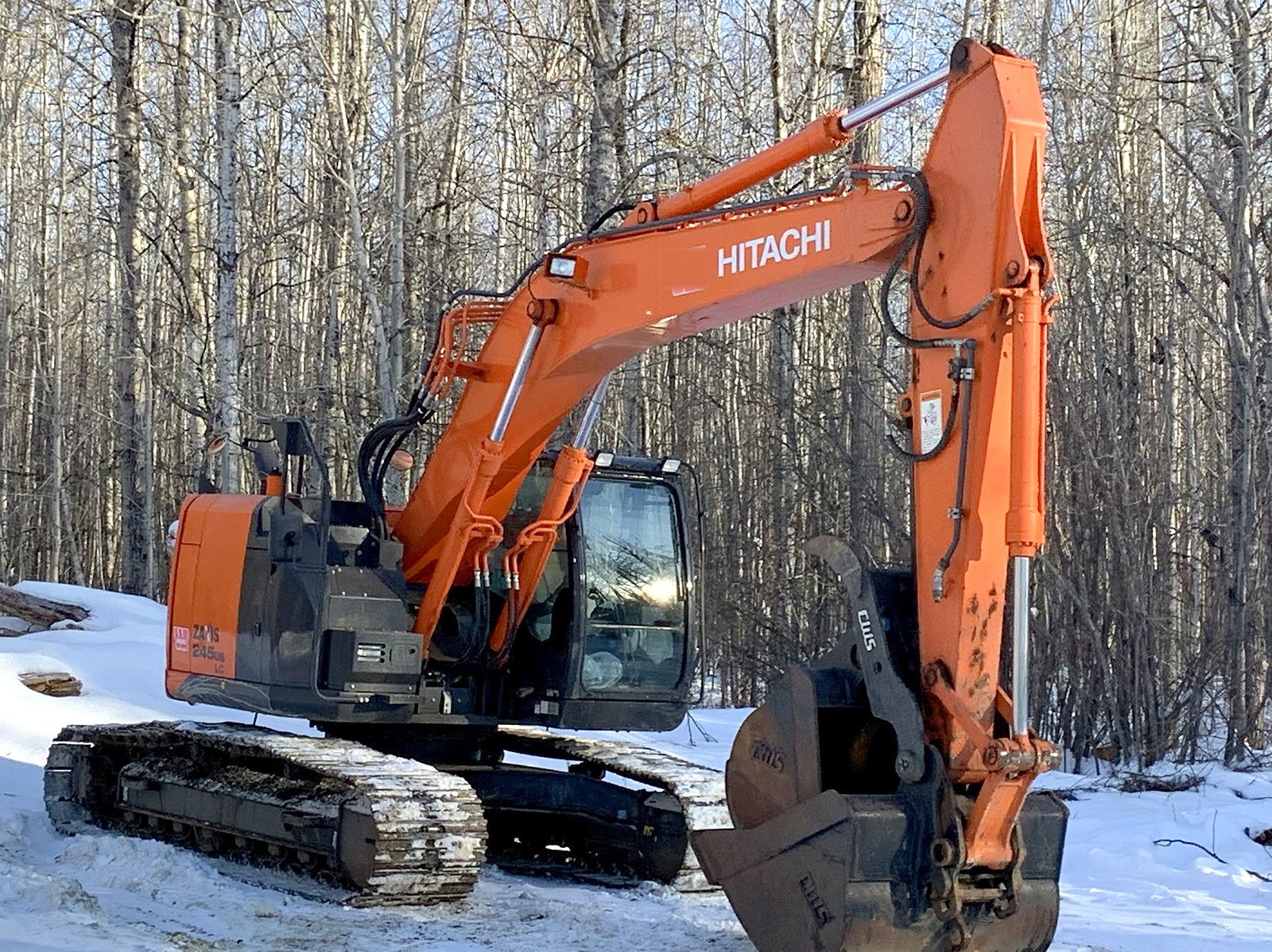 The group's Hitachi ZX245 excavator working a cutline in snow
