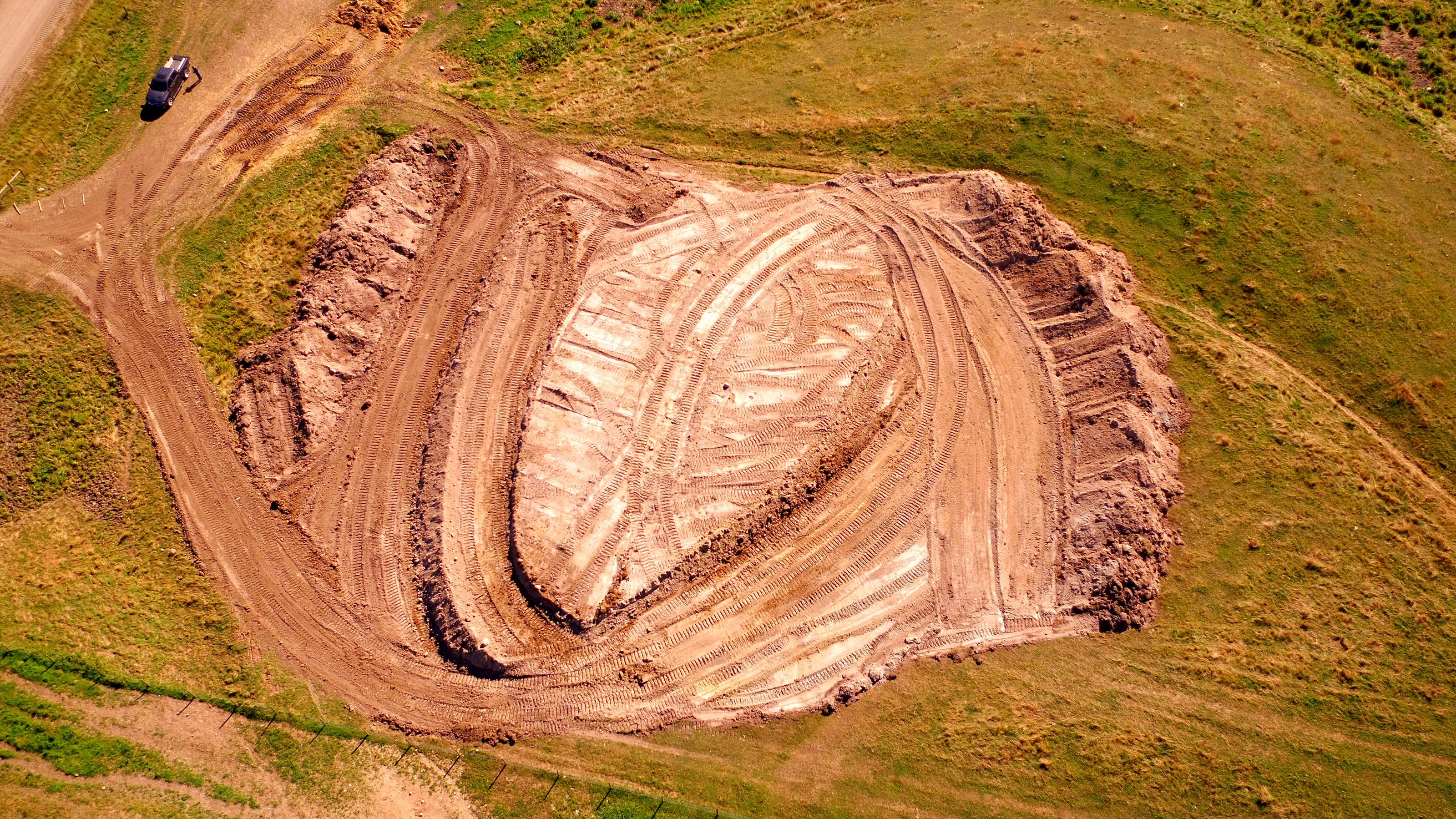 Cutting a borrow pit on the group's own land, from the air